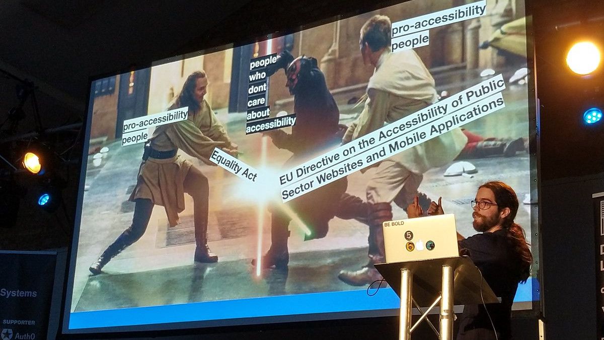 Nick stood in front of a slide using Star Wars to explain accessibility legislation. Jedis are using the Equality Act and Public Sector Accessibility Regulations as a weapon against the Sith.